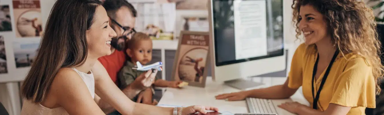 HR manager discussing summer travel with employee and family at a desk