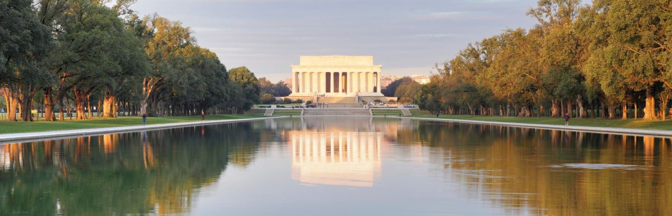 United States Lincoln Memorial photo from a distance overlooking pond with trees on each side reflected in the water